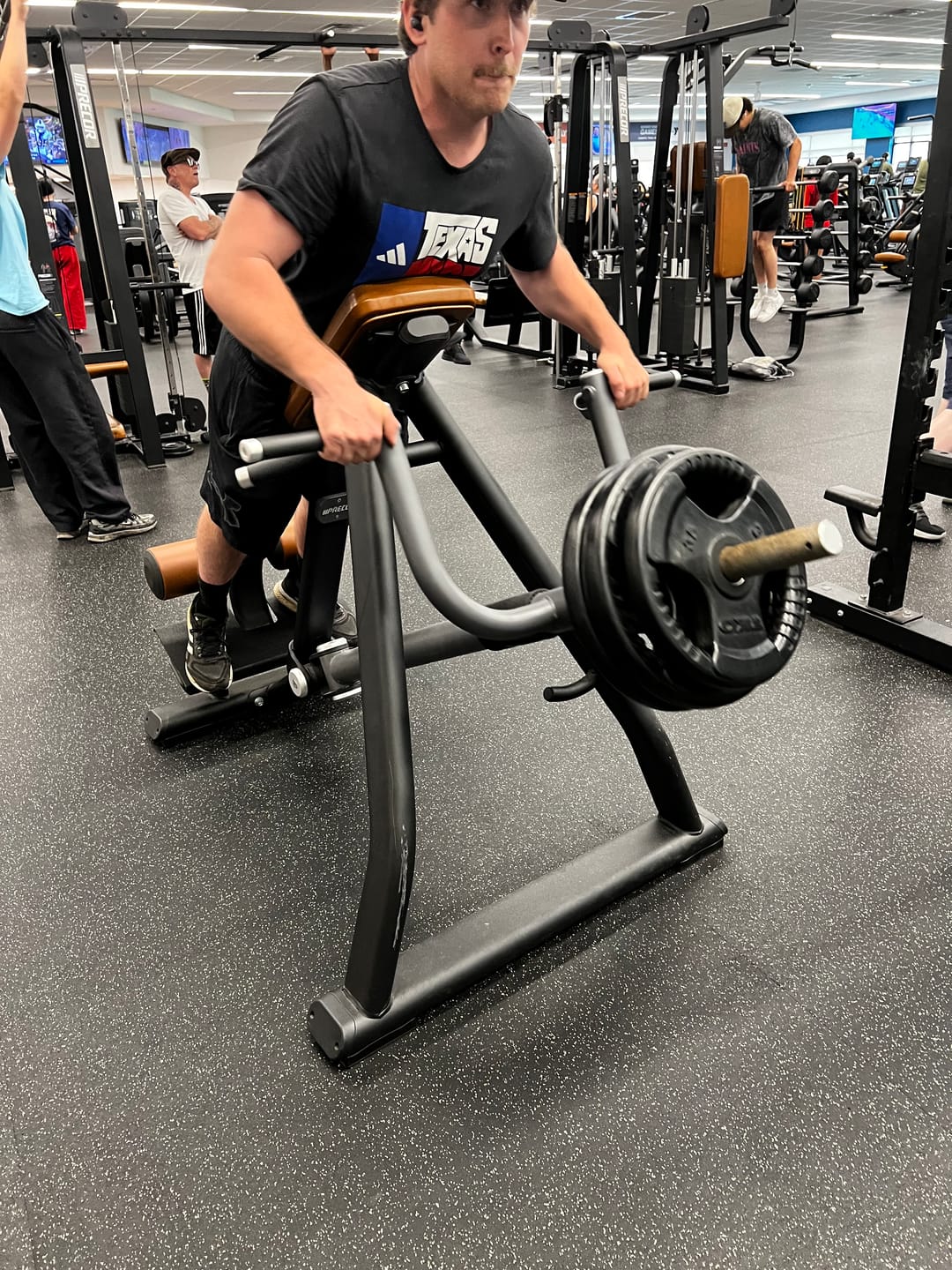 Athlete training on a plate-loaded row machine in the gym