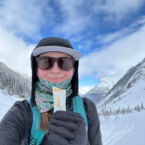 Skier holding a RONE sachet in the mountains